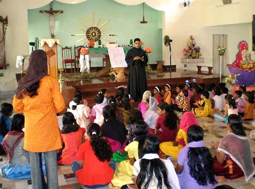 An Augustinian in India assists catechetical instruction of children.
